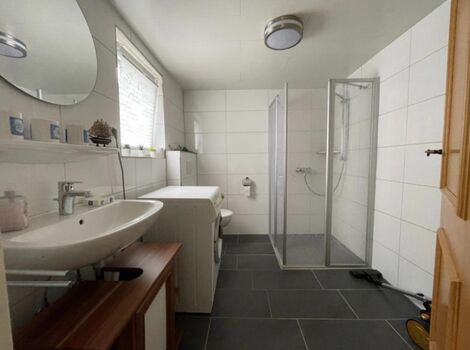 Badezimmer mit Fenster und begehbarer Dusche im EG