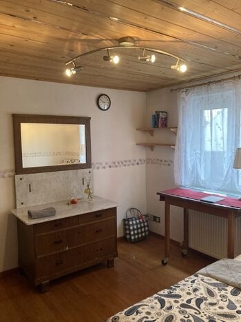 kleines Zimmer mit Einzelbett und Echtholzkommode  