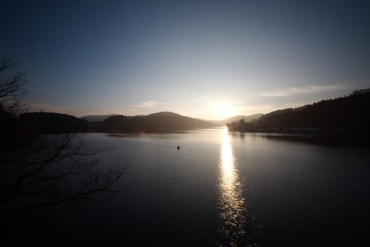 Blick von der Uferstraße unterhalb des Sankt Muffert über den Diemelsee im abendlichen Gegenlicht