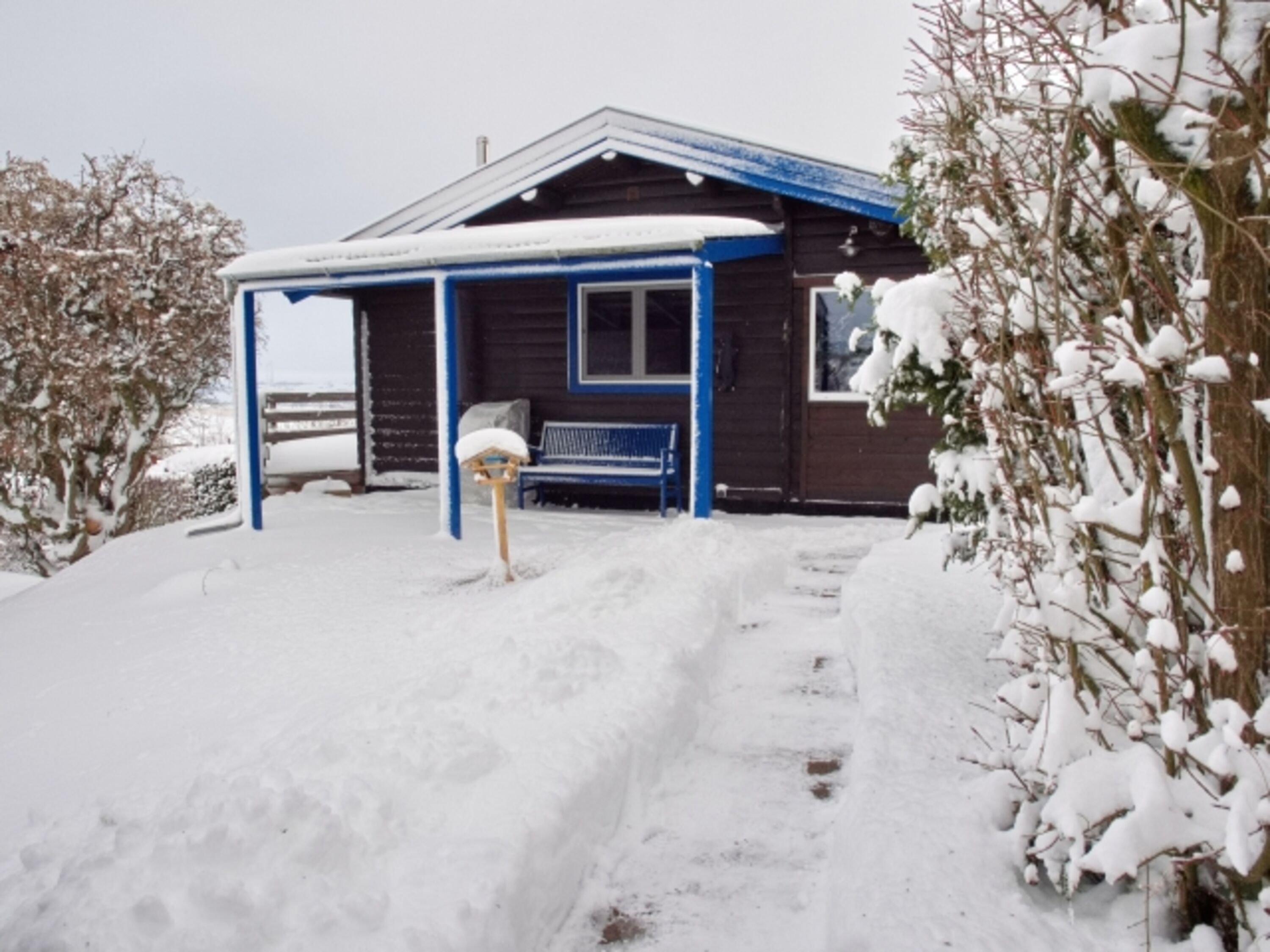Grundstückszugang zur verschneiten überdachten Terrasse und zum Ferienhaus
