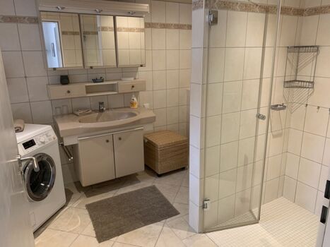 Das große Badezimmer mit bodentiefer Dusche.