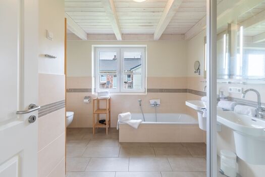 Badezimmer mit Dusche, Wanne und Sauna