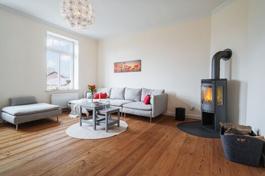 Großzügiges Wohnzimmer mit gemütlichem Sofa und Kaminofen