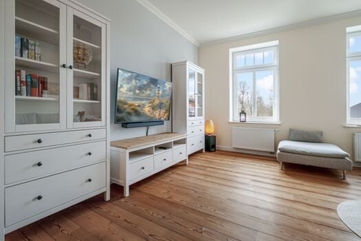 Wohnzimmer mit Smart-TV, Büchern und Spielen