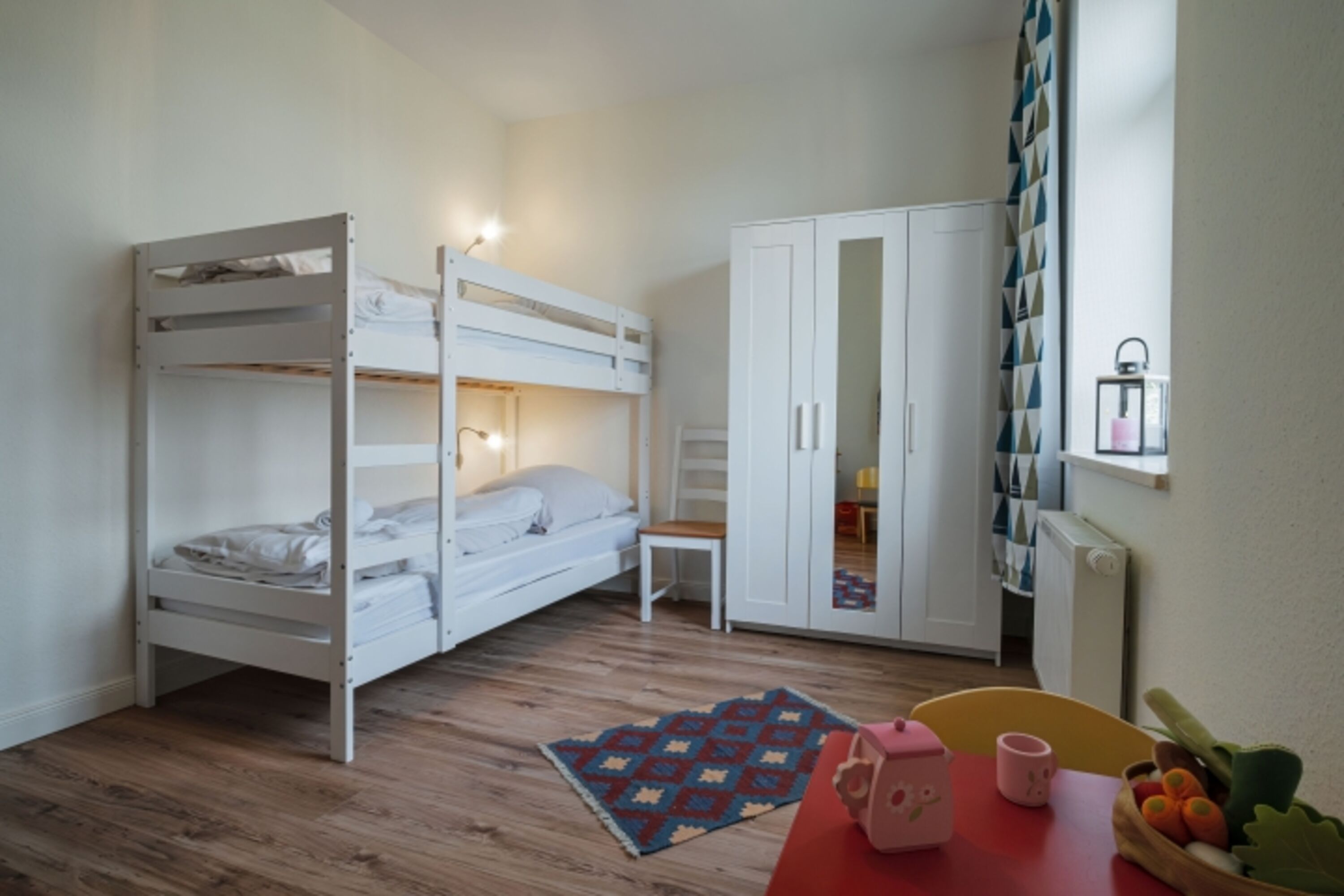 Kinderzimmer mit Etagenbett und Spielecke