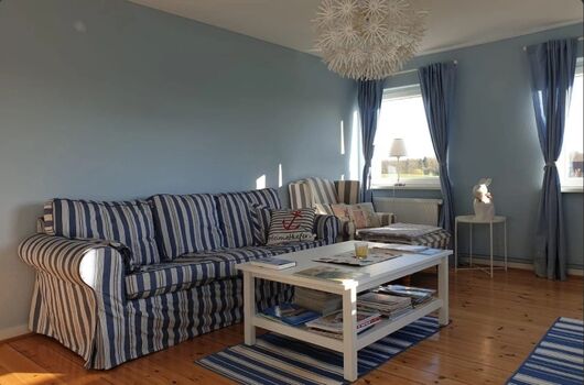 Wohnzimmer mit Holzmöbeln und Fensterdekoration