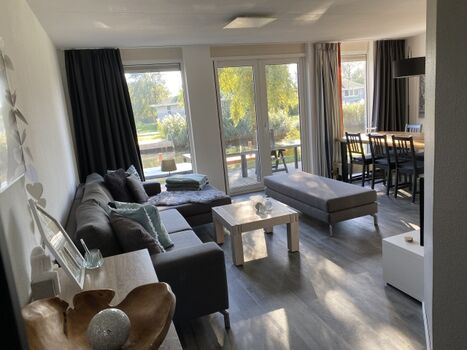 Wohn- Essbereich mit Couch und Blick aufs Wasser