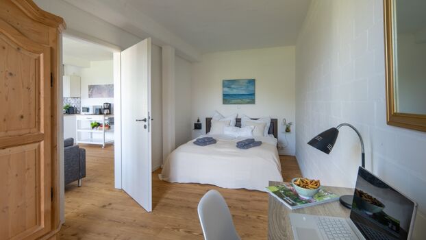 Schlafzimmer mit Doppelbett und Schreibtisch