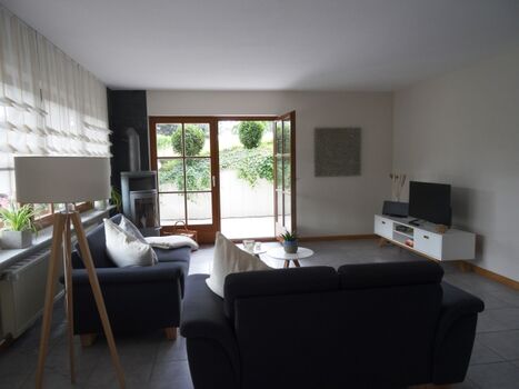 Großzügiges Wohnzimmer mit Zugang zum überdachten Freisitz