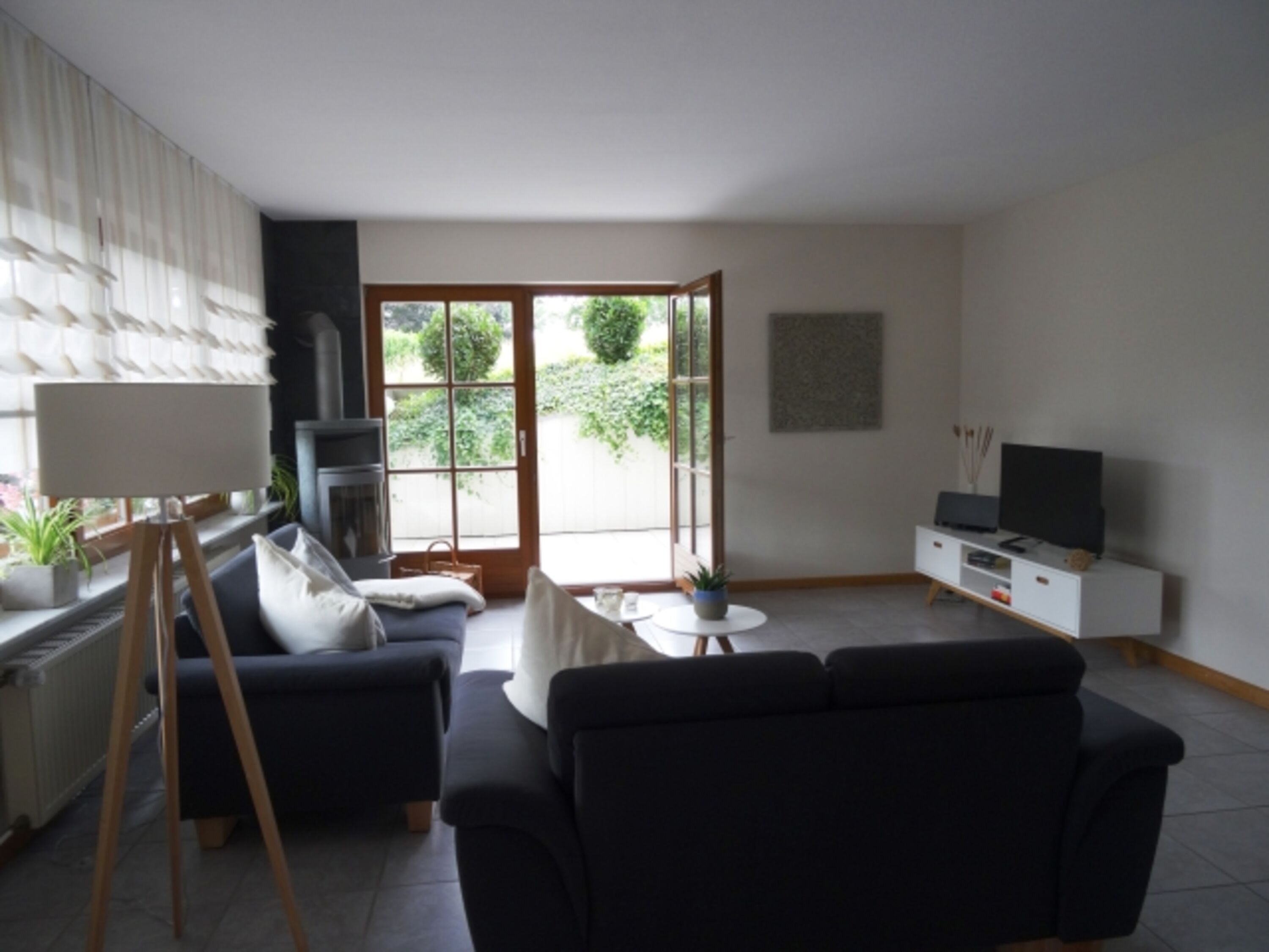 Großzügiges Wohnzimmer mit Zugang zum überdachten Freisitz