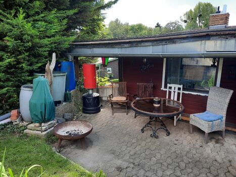 Überdachte Sitzgelegenheit mit Feuerschale und Grill