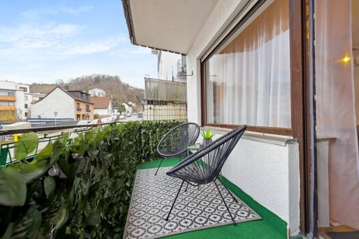 Kleiner Balkon mit Loungemöbel und Blick auf die Emser Berge