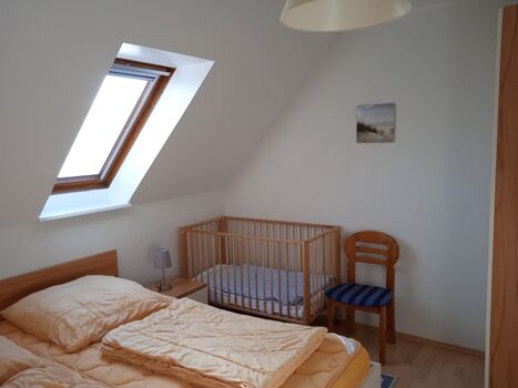 Schlafzimmer 1 im 1.OG mit Doppelbett und Kleinkindklappbett