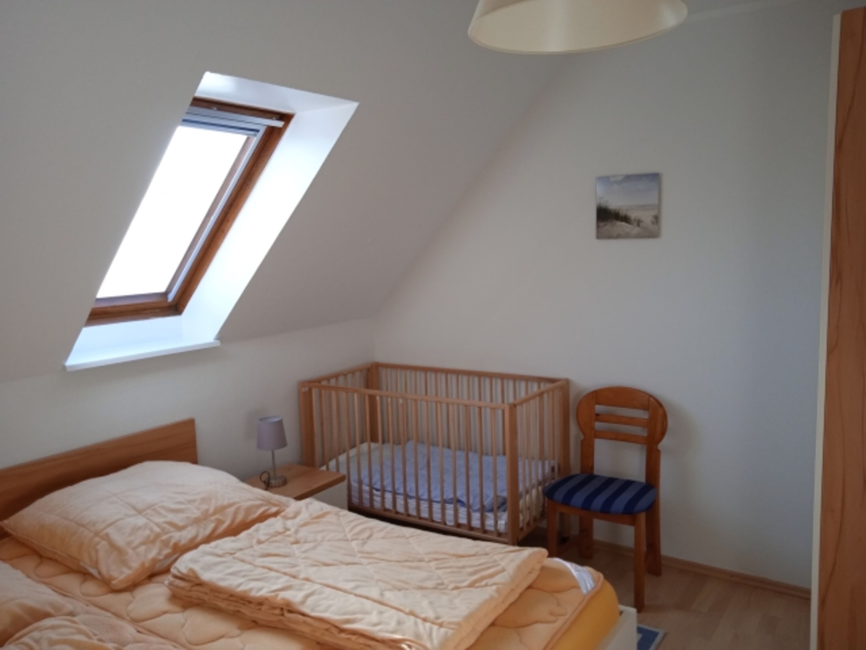 Schlafzimmer 1 im 1.OG mit Doppelbett und Kleinkindklappbett