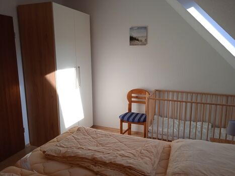 Schlafzimmer 1 im 1.OG mit Doppelbett und Kleinkindklappbett