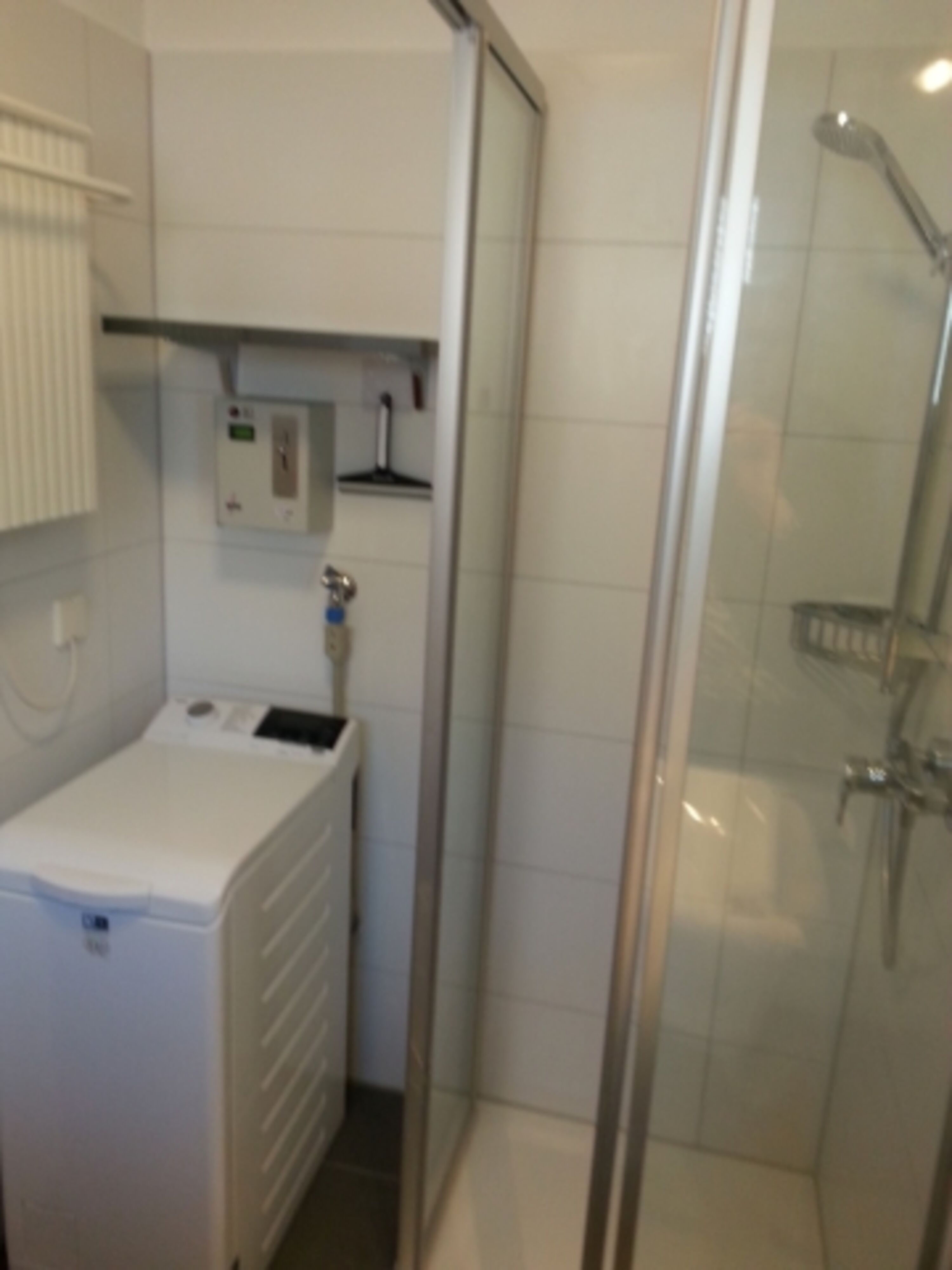 Waschmaschine und Dusche im Bad