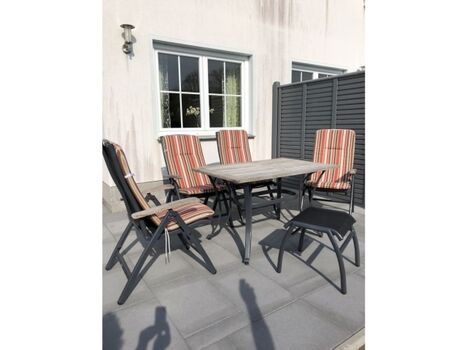 Große Sonnenterrasse mit Gartenmöbeln und Sonnenliegen