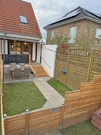 vollständig eingezäunte Terrasse mit Garten und Gasgrill