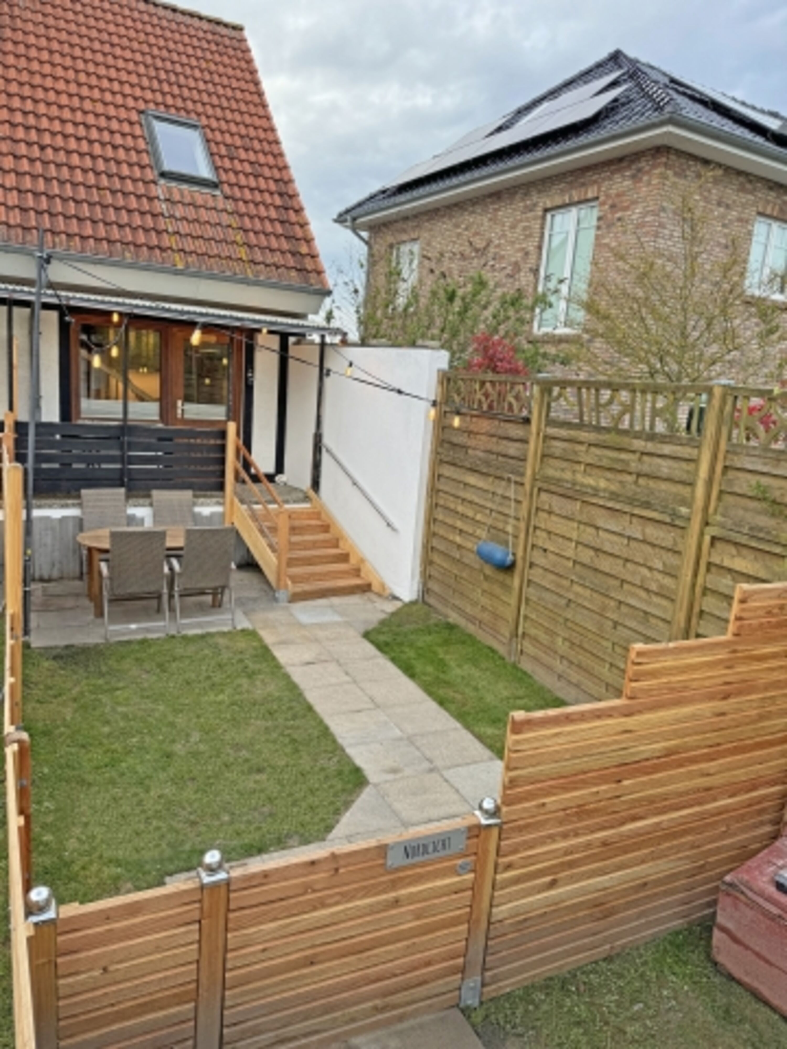 vollständig eingezäunte Terrasse mit Garten und Gasgrill