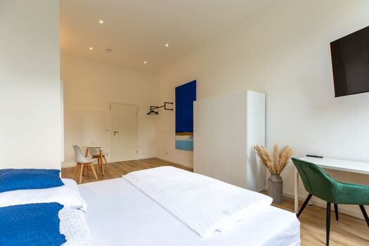 Schlafzimmer II mit Schreibtisch, TV,  Garderobe 