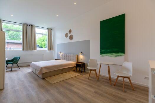 Schlafzimmer 5, mit Doppelbett, Schreibtisch, Kleiderschrank, Sitzecke und TV