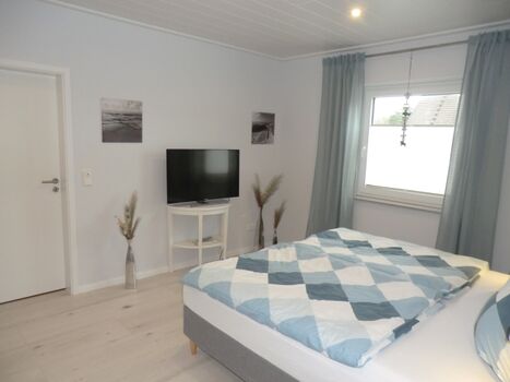 Modernes Schlafzimmer mit Boxspringbett und TV.