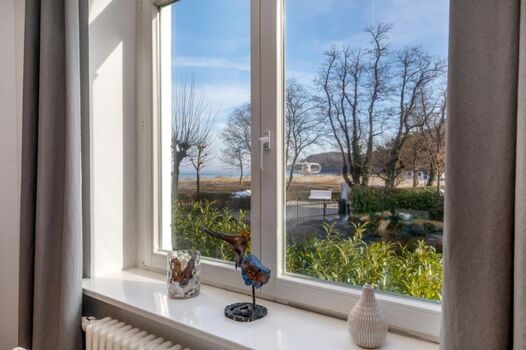 Der Blick aus einem Erkerfenster zum Wasser.