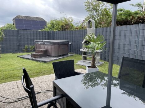 Terrasse mit Blick auf den Whirlpool und die Palme 