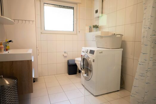 Badezimmer mit Waschtrockner und Handtuchwärmer