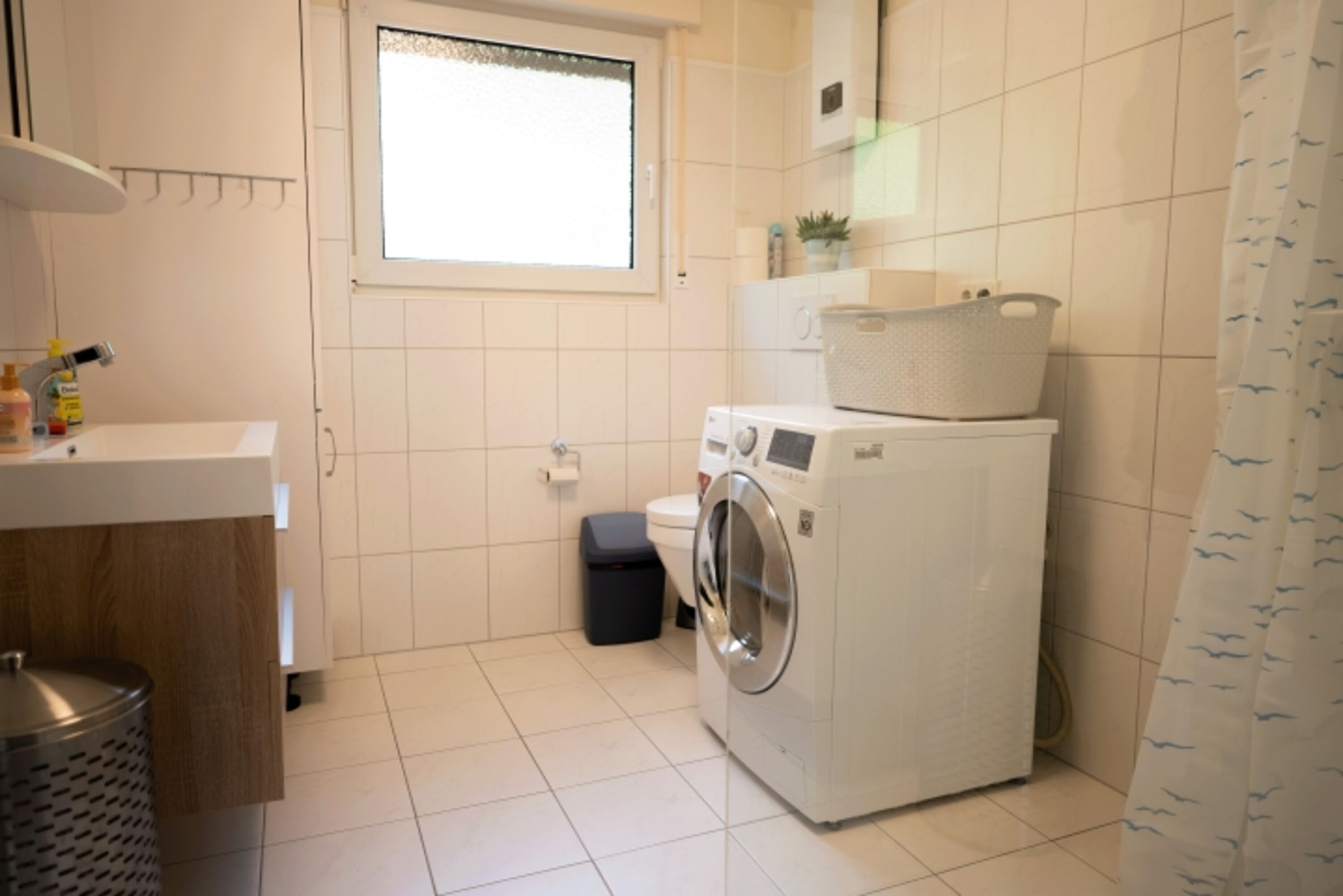 Badezimmer mit Waschtrockner und Handtuchwärmer