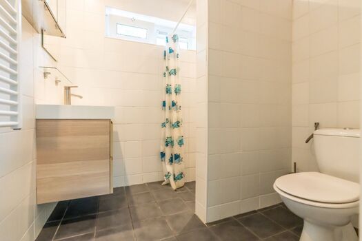 Badezimmer mit Dusche, Toilette und Waschbecken