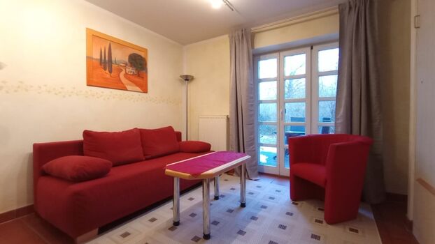 Die Sitzgruppe mit Schlafsofa; im Hintergrund die eigene Terrasse