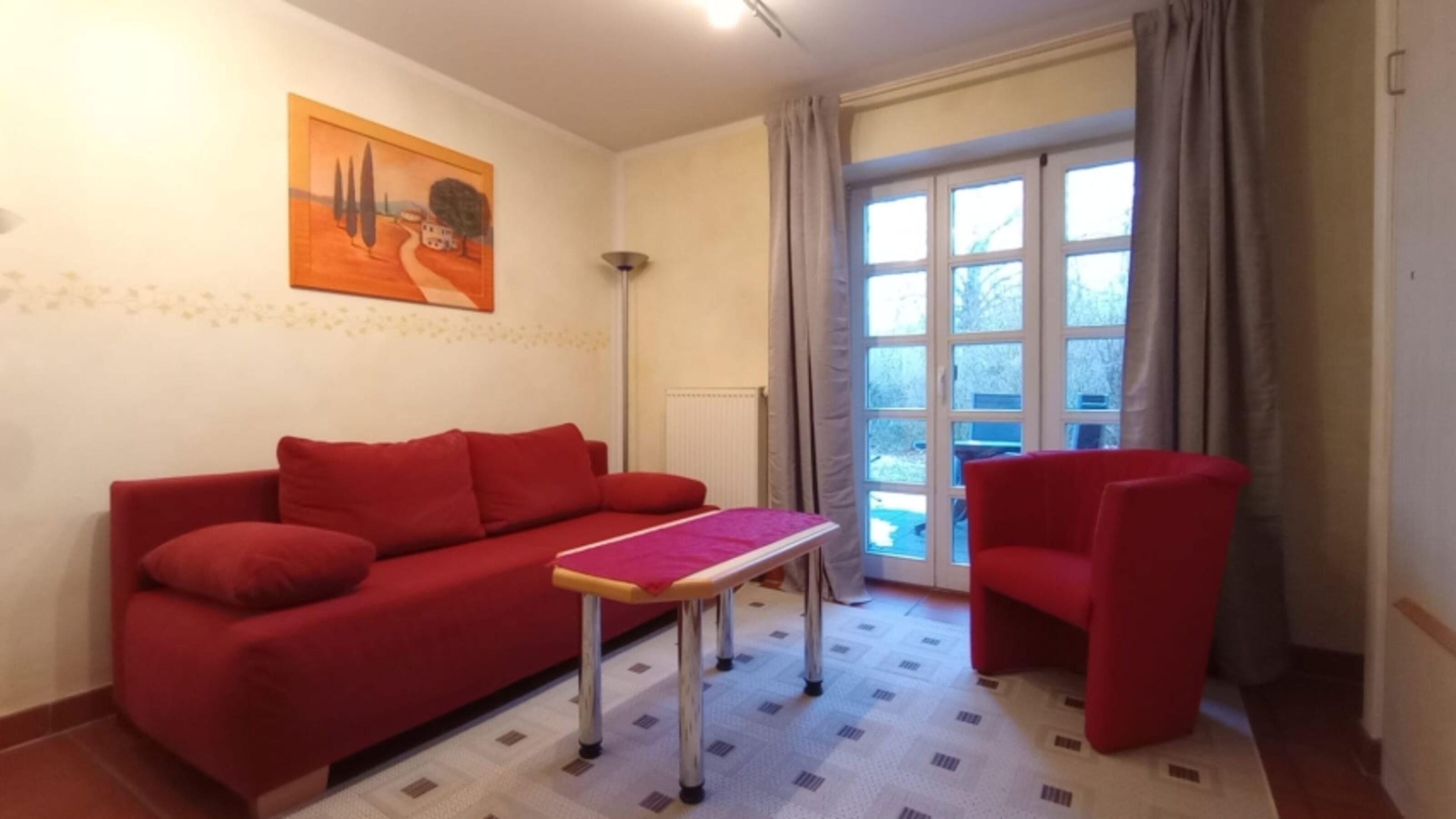 Die Sitzgruppe mit Schlafsofa; im Hintergrund die eigene Terrasse
