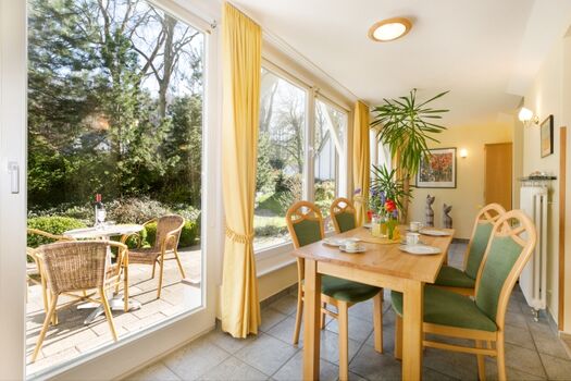 Blick in den Wintergarten und auf die Terrasse.