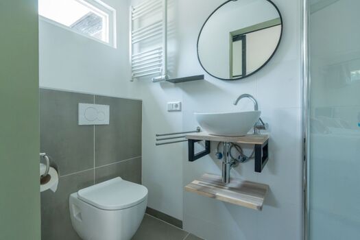 Das neue Badezimmer mit Regendusche, Waschbecken und Toilette