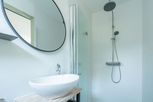 Das neue Badezimmer mit Regendusche, Waschbecken und Toilette