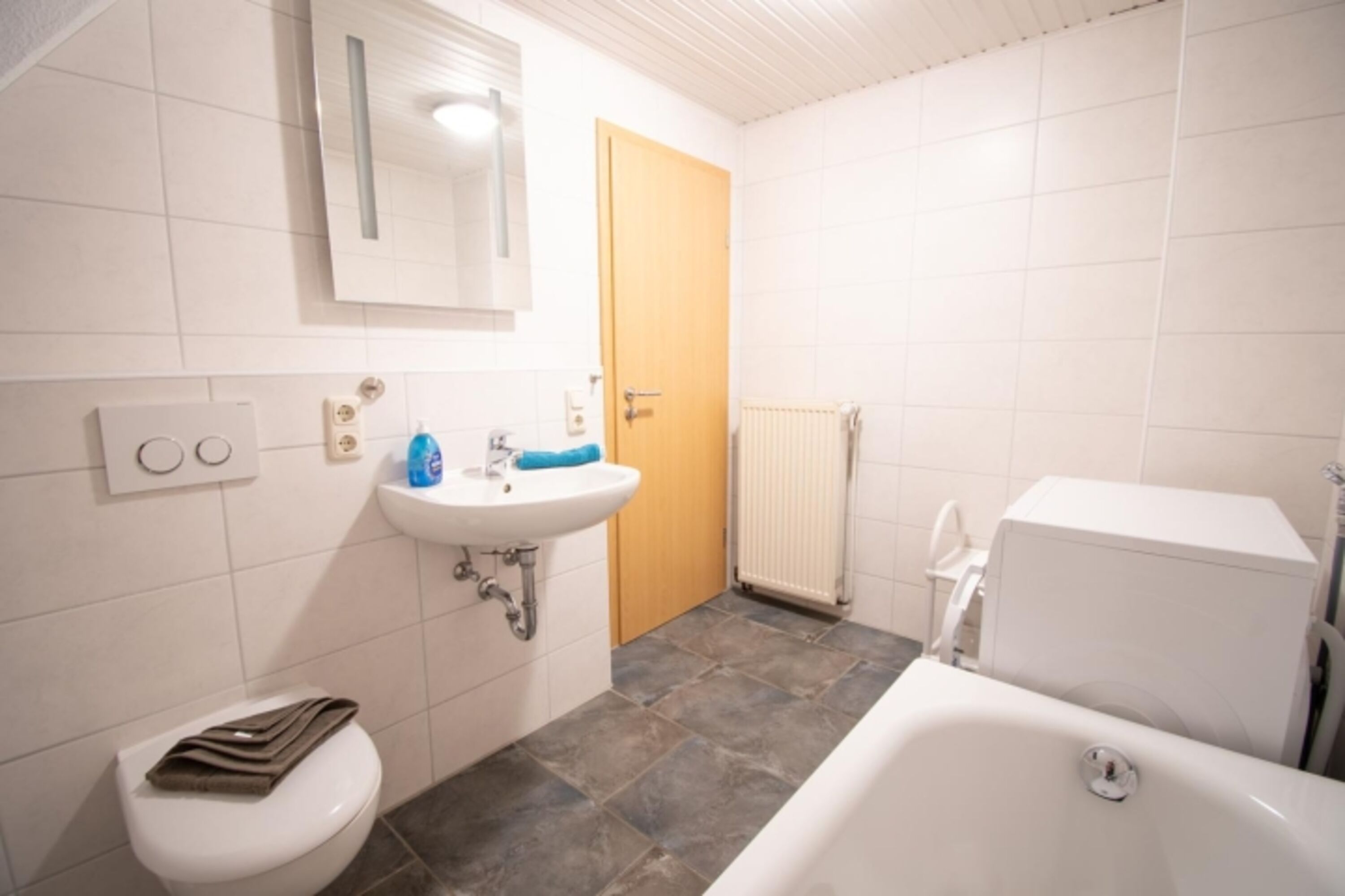 Badezimmer oben mit Badewanne und Waschmaschine
