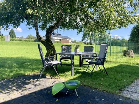 Gemütlicher Sitzplatz mit Liegestühle sowie Grill unterm Baum