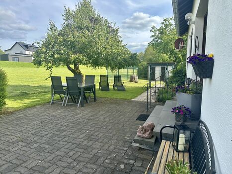 Vor dem Haus mit Blick auf den eingezäunten, ausbruchsicheren Garten