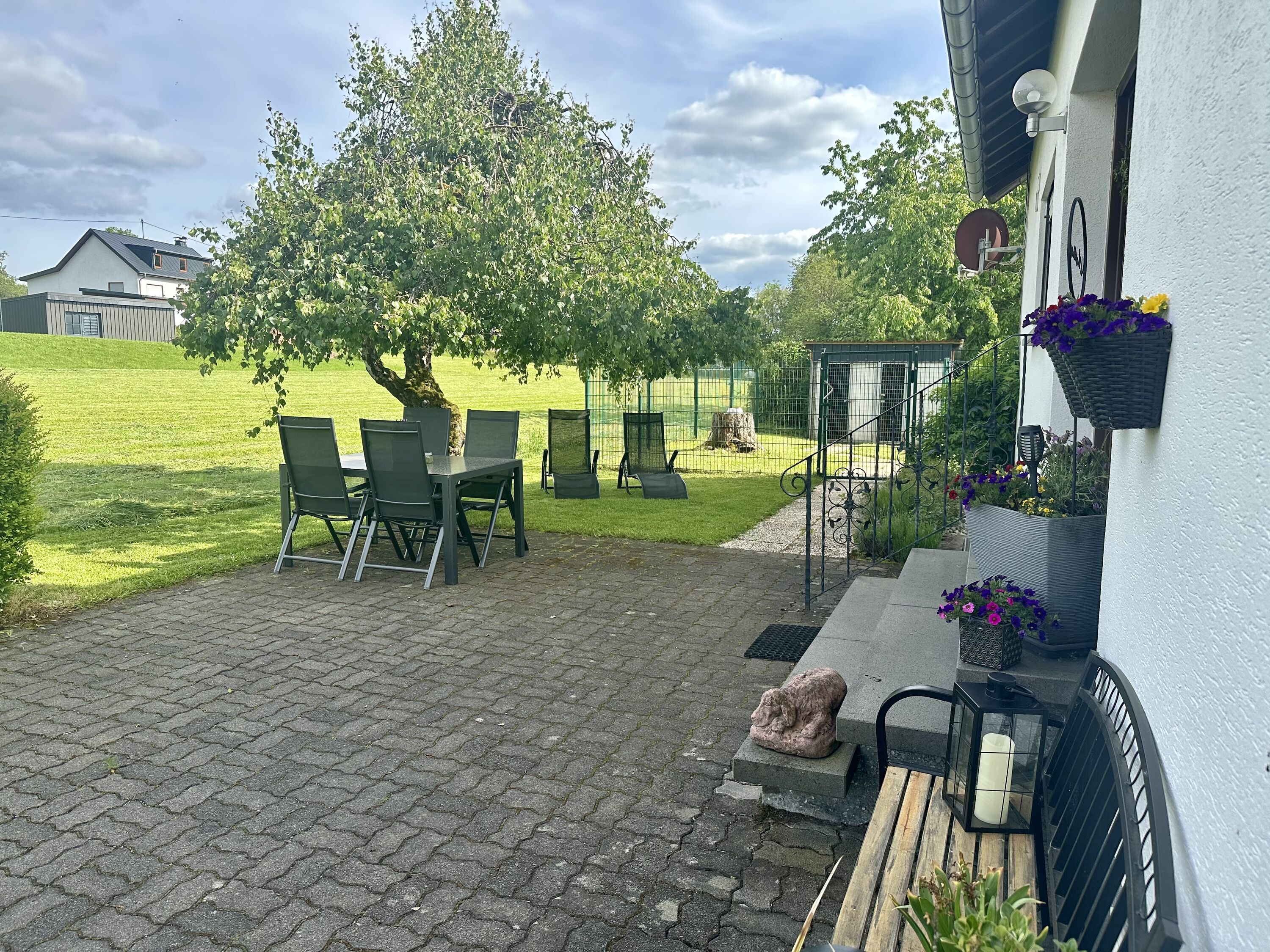 Vor dem Haus mit Blick auf den eingezäunten, ausbruchsicheren Garten