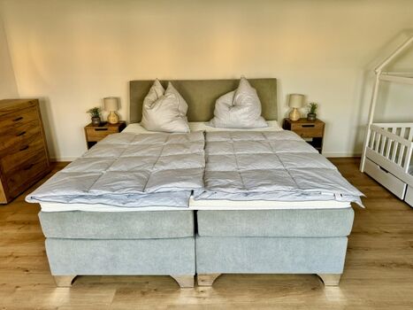 Schlafzimmer unten mit einem gemütlichen Boxspringbett