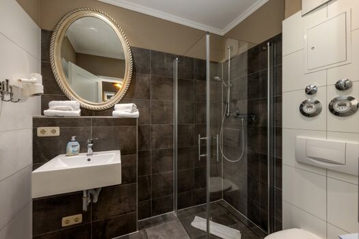 Das Bad mit bodengleicher Echtglasdusche.