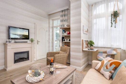 Wohnzimmer mit elektrischem Kamin und Schreibtisch.