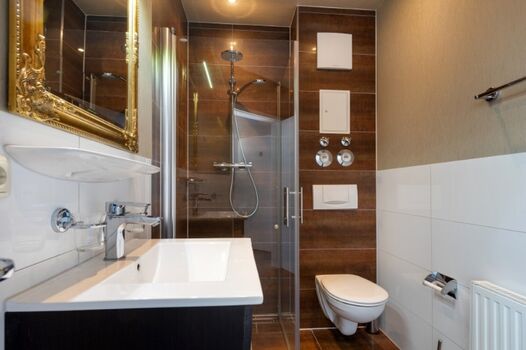 Das Bad mit bodengleicher Echtglasdusche.