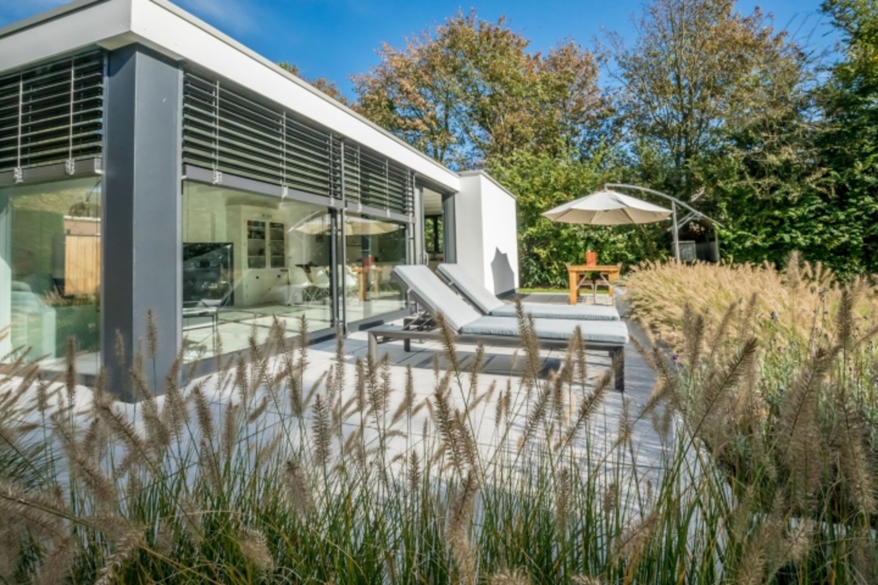 Die Terrasse mit Gartengruppe, Liegen und Sonnenschirm
