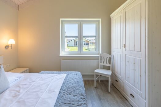 Wolken Blick: Schlafzimmer mit Doppelbett und Kleiderschrank