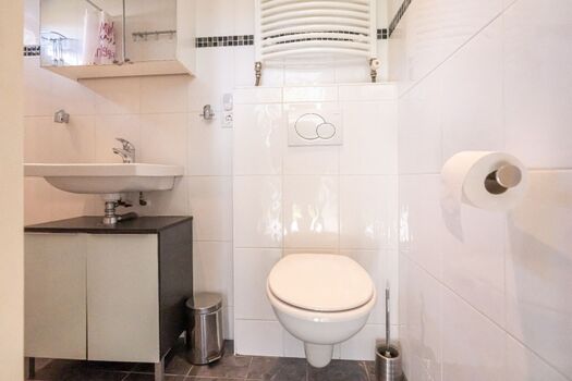 Badezimmer mit Dusche, Waschbecken und Toilette