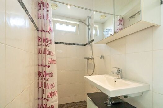 Badezimmer mit Dusche, Waschbecken und Toilette