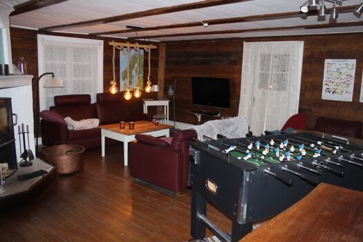 großes Wohnzimmer mit Kamin und Kicker und Ausgang zur überdachten Veranda