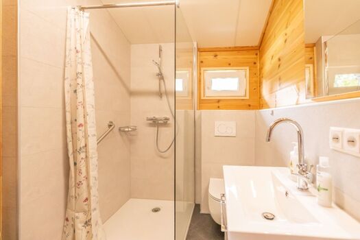 Das Badezimmer mit Dusche, Waschbecken, WC und Waschmaschine